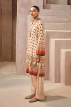 Woman wearing a patterned kurta with shalwar pants in a neutral setting