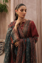 Woman wearing a traditional outfit with a patterned shawl indoors.